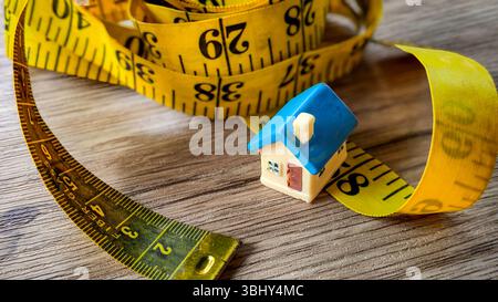 Miniatur-Haus auf einem Maßband Stockfoto