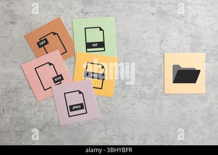Eine Gruppe von Symboldateien (PNG, TIFF, JPEG, GIF, SVG), getrennt durch ein Ordnersymbol – Eine visuelle Darstellung der Dateiformate, die für einfachen Zugriff und M organisiert sind Stockfoto