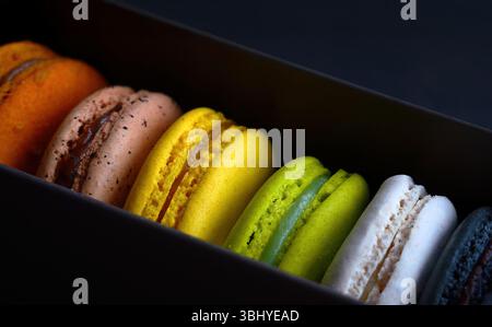 Eine Reihe von raffinierten, farbigen Makronen in einer Box, französischer Snack, Gebäckrezept, Mandelmehl, Makroaufnahmen Makronen Kekse Dessert Stockfoto