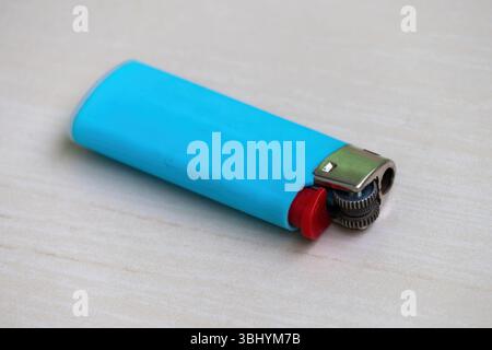 Rostblauer Kunststoff-Gasanzünder auf Holz. Stockfoto