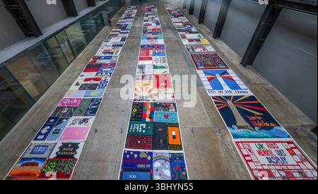 Tate Modern, London, Großbritannien. Juni 2025. Es begann um 1989, diese umfangreiche Arbeit besteht aus 42 Quilts und 23 Einzelpaneelen, die 384 von HIV und AIDS betroffene Personen repräsentieren. Sie wird in einem Raster über dem Boden der Turbinenhalle angeordnet und spiegelt wider, wie sie zuvor im Freien gezeigt wurde, um das Bewusstsein für die anhaltende AIDS-Pandemie zu schärfen. Dies ist eine seltene Gelegenheit, das Werk vollständig zu fotografieren.Paul Quezada-Neiman/Alamy Live News Credit: Paul Quezada-Neiman/Alamy Live News Stockfoto