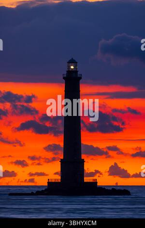Silhouette des Leuchtturms von Phare de la Hague vor einem lebendigen Sonnenuntergangshimmel in der Normandie, Frankreich Stockfoto