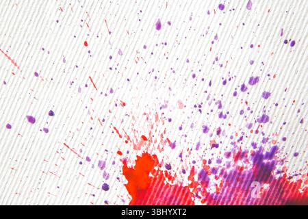 Abstrakter künstlerischer Hintergrund: Rote und blaue Farbspritzer auf weiß gestreifter Leinwand Stockfoto