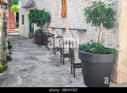 Die gemütliche Bar im Freien verfügt über Holzhocker und kleine Tische Stockfoto
