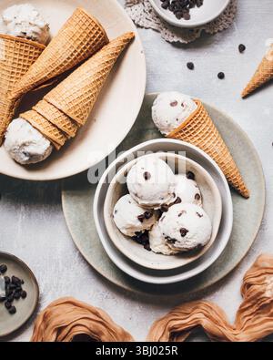 Köstliche Bananeneiskörner mit Schokoladenchips werden in knusprigen Waffelkegeln serviert. Zu den Zutaten gehören griechischer Joghurt und reife Bananen Stockfoto