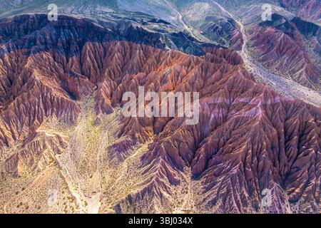 Ein Blick aus der Vogelperspektive auf die Erosion der Rinne in einer lebendigen Landschaft, die zerklüftetes Gelände und komplizierte Muster zeigt, die durch natürliche Prozesse im Laufe der Zeit in einem Halbkreis entstanden sind Stockfoto