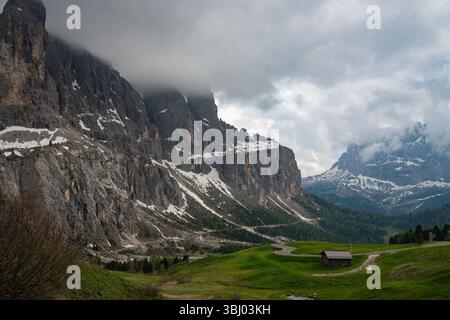 Majestätische Aussicht auf das Val di Funes in den Dolomiten, Italien, mit sanften grünen Hügeln, zerklüfteten Klippen und einer ruhigen Berglandschaft unter einer dramatischen Kulisse Stockfoto
