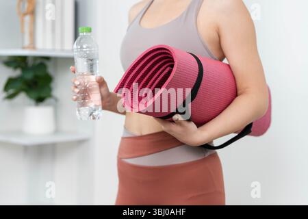 Yoga Essentials. Junge Frau mit Yogamatte und Trinkflasche für das Training. Stockfoto