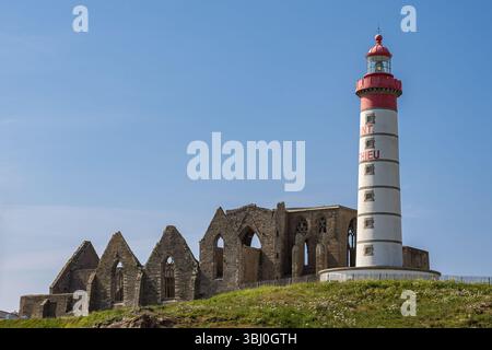 Blick auf den Leuchtturm und die Ruinen der Abbaye Saint-Mathieu de Fine-Terre am Saint-Mathieu Point, Finistère, Bretagne, unter klarem blauem Himmel Stockfoto