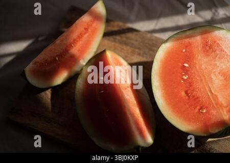 Vaicājums ir izpildīts Wassermelonenscheiben auf Holzbrett bei Sonnenlicht Stockfoto