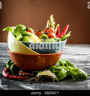 Frisches Gemüse und Gewürze in einer Schüssel auf dem Tisch Stockfoto