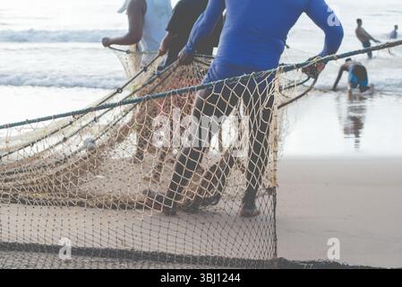 Ein halber Körper von nicht identifizierten Fischern, die ein Fischernetz ziehen. Angelsport. Brasilien Stockfoto