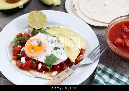 Huevos Rancheros. Traditionelles mexikanisches Frühstück auf Holztisch Stockfoto