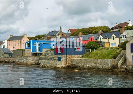 Scalloway, die ehemalige Hauptstadt von Shetland, verbindet reiche Geschichte, farbenfrohe Hafenleben und dramatische Küstenschönheiten in einem unvergesslichen Dorf. Stockfoto