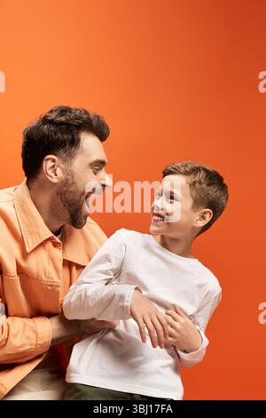 Vater und Sohn teilen fröhliche Momente zusammen und feiern Liebe und Verbindung am Vatertag. Stockfoto