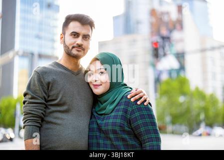 Porträt eines glücklichen muslimischen Paares, das sich in der Stadt umgibt Stockfoto