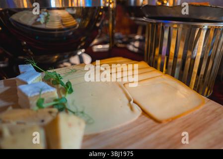Nahaufnahme einer eleganten Käseplatte mit verschiedenen Käsesorten und Kräutern Stockfoto