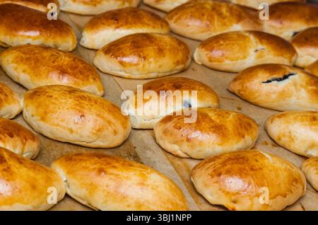 Gebackene Brötchen gefüllt mit Johannisbeermarmelade auf Pergamentpapier. Stockfoto