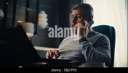 Professioneller Börsenmakler telefonisch, Analyse von Echtzeitaktien und Börsendiagrammen mit Laptop-Computer. Erfolgreicher Investmentagent arbeitet im Cozy Office of Financial Agency. Stockfoto