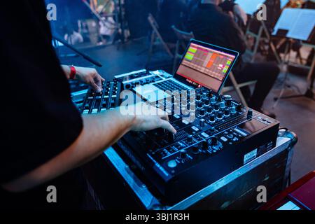 DJ oder Tontechniker, der an einer Konsole und einem Laptop arbeitet Stockfoto