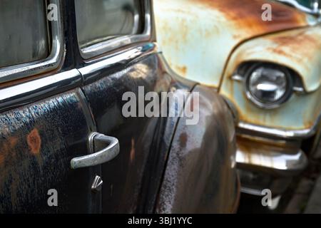 Selektiver Fokus auf den Türgriff eines Buick Eight Motorwagens aus den 1950er Jahren, das vor einem Cadillac Coupe de Ville aus den 1950er Jahren geparkt wurde Stockfoto