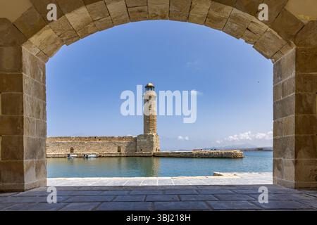 Eine mediterrane Altstadt. Ein historischer Leuchtturm aus Stein. Blick bei Tag mit blauem Himmel auf die Stadt in Rethymno, Kreta, Griechenland Stockfoto