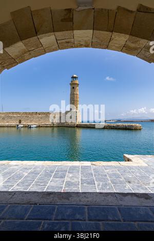 Eine mediterrane Altstadt. Ein historischer Leuchtturm aus Stein. Blick bei Tag mit blauem Himmel auf die Stadt in Rethymno, Kreta, Griechenland Stockfoto
