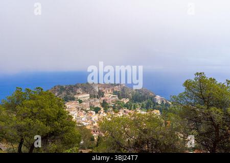 Blick von oben auf Taormina mit dem mittelalterlichen Stadtzentrum, dem antiken griechischen Theater und der Küste, die auf Sizilien, Italien, sichtbar ist Stockfoto