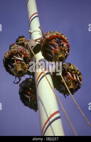 Maypole England. Barwick in Elmet Maypole Erziehungszeremonie. Die 86 Meter lange hölzerne Maische bemalt und repariert, ein einheimischer Mann, der die neuen Girlanden an der Spitze des Maypols befestigt. Barwick in Elmet, West Yorkshire, England, 1970er Jahre HOMER SYKES Stockfoto