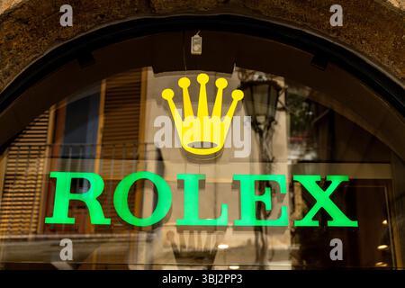 Taormina, Sizilien - Italien - 05-04-2025: Nahaufnahme des Rolex-Schaufensters in Taormina, Sizilien, mit grünem Rolex-Text und gelbem Kronenlogo mit Refle Stockfoto