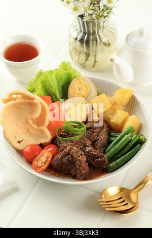 Selat Solo Salat, bekannt als javanisches Steak. Geschmortes Rindersteak in süßer Sojasauce mit Eiern, Kartoffeln und Karotten. Stockfoto