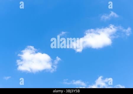Niedriger Winkel und voller Rahmen des wunderschönen blauen Himmels mit seltsamer Form von weißen flauschigen Wolken am Morgen oder Nachmittag an sonnigen Tagen Stockfoto
