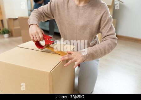 Umzug, Umzug. Frau wählen und packen, um zu spenden, bevor sie nach Hause ziehen, Paar helfen, Möbel für neue Wohnung einzurichten und zu verschieben. Bewegen Sie sich in der neuen Apar Stockfoto