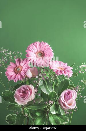 Schöner Blumenstrauß mit rosa Gerbera-Blüten auf grünem Hintergrund. Wunderschöner romantischer Blumenstrauß. Vorderansicht mit Kopierraum. Stockfoto