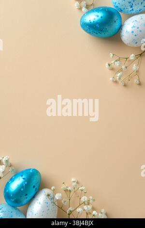 Osterfeierlichkeit Konzept. Flache Lay-Komposition mit bunten gesprenkelten Eiern und zarten weißen Blüten auf beigefarbenem vertikalem Hintergrund Stockfoto