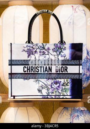 London, Vereinigtes Königreich - 26. Mai 2025: Eine stilvolle Christian Dior Tragetasche mit Blumenmotiven, die vor dem Hintergrund dekorativer Laternen präsentiert wird Stockfoto