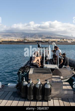 Taucher bereiten ihre Ausrüstung auf einem Boot vor, bereit für einen Tauchausflug in den Gewässern von teneriffa, den kanarischen Inseln Stockfoto