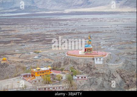 Maitreya Buddha Statue im Diskit Kloster, Nubra Valley, Ladakh, Indien - ein majestätisches spirituelles Wahrzeichen vor den dramatischen Himalaya-Bergen Stockfoto
