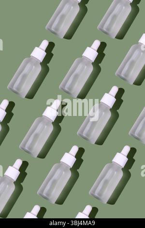 Weiße transparente Kosmetikflasche mit Pipette, grüner Hintergrund Stockfoto