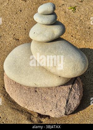 Gestapelte Steine am Strand. Ungewöhnlich geformte Steine. Steinpyramide. Steine am Strand. Steine auf dem Sand. zen Stockfoto