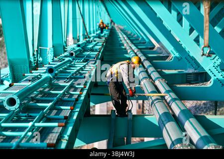 (250613) -- GUANLING, 13. Juni 2025 (Xinhua) -- Arbeiter bauen einen Sightseeing-Korridor auf der Baustelle der Huajiang Grand Canyon Brücke in der südwestlichen chinesischen Provinz Guizhou, 11. Juni 2025. Touristische Ausrüstung an der Huajiang Grand Canyon Bridge wird derzeit gebaut. Die Hängebrücke hat eine senkrechte Höhe von 625 Metern vom Brückendeck bis hinunter zur Flussoberfläche – etwa doppelt so hoch wie der Eiffelturm. Die 2.890 Meter lange Brücke mit einer Spannweite von 1.420 Metern ist auch die weltweit größte Spannbrücke, die in einem bergigen Gebiet gebaut wurde. Es wird erwartet, dass es für Traffi geöffnet wird Stockfoto