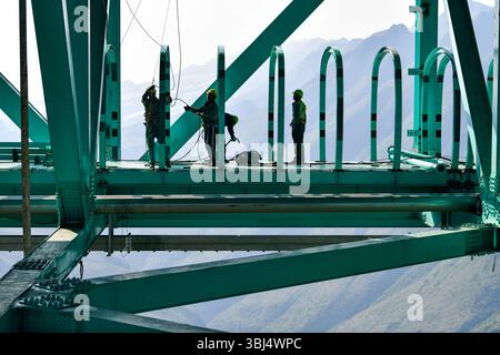 (250613) -- GUANLING, 13. Juni 2025 (Xinhua) -- Arbeiter bauen einen Sightseeing-Korridor auf der Baustelle der Huajiang Grand Canyon Brücke in der südwestlichen chinesischen Provinz Guizhou, 11. Juni 2025. Touristische Ausrüstung an der Huajiang Grand Canyon Bridge wird derzeit gebaut. Die Hängebrücke hat eine senkrechte Höhe von 625 Metern vom Brückendeck bis hinunter zur Flussoberfläche – etwa doppelt so hoch wie der Eiffelturm. Die 2.890 Meter lange Brücke mit einer Spannweite von 1.420 Metern ist auch die weltweit größte Spannbrücke, die in einem bergigen Gebiet gebaut wurde. Es wird erwartet, dass es für Traffi geöffnet wird Stockfoto