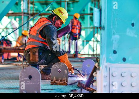 (250613) -- GUANLING, 13. Juni 2025 (Xinhua) -- Arbeiter installieren ein Gerät für X-Sports auf der Baustelle der Huajiang Grand Canyon Brücke in der südwestlichen chinesischen Provinz Guizhou, 11. Juni 2025. Touristische Ausrüstung an der Huajiang Grand Canyon Bridge wird derzeit gebaut. Die Hängebrücke hat eine senkrechte Höhe von 625 Metern vom Brückendeck bis hinunter zur Flussoberfläche – etwa doppelt so hoch wie der Eiffelturm. Die 2.890 Meter lange Brücke mit einer Spannweite von 1.420 Metern ist auch die weltweit größte Spannbrücke, die in einem bergigen Gebiet gebaut wurde. Es wird erwartet, dass es für Traff geöffnet wird Stockfoto