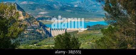 Ein Panoramablick auf den Iznajar-Stausee im Fluss Genil in Südspanien, mit dem Damm, der an einem sonnigen Frühlingstag in der Mitte steht Stockfoto