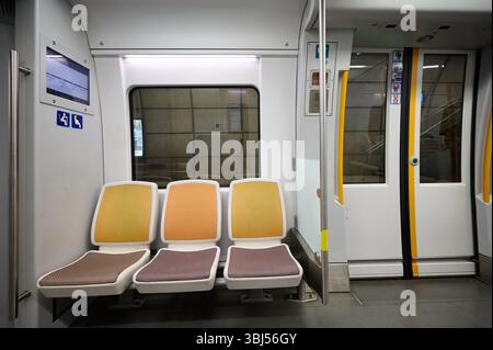 Komfortable, farbenfrohe Sitze erwarten Passagiere in einem sauberen, hellen und modernen U-Bahn-Auto, das für die nächste Reise bereit ist Stockfoto