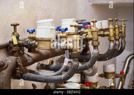 Nahaufnahme von Wasserzählern und Ventilen, die den Wasserdurchfluss in einem Wohngebäude regulieren, um eine genaue Messung des individuellen Verbrauchs zu gewährleisten Stockfoto