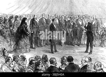 Die Mehrheit des Prinzen Imperial: Der Duc de Padoue liest die Adresse am Camden Place, Chiselhurst [sic], 1874. Zeremonie anlässlich des Erwachsenenalters von Louis-Napoléon, Prinz Imperial (1856-1879), der mit seinen Eltern Napoleon III., Kaiser der Franzosen, und Kaiserin EUGénie im Exil lebte. Einige Nachbarn des Prinzen Imperial in Chiselhurst haben kürzlich ein Geburtstagsgeschenk abonniert, das von Mr. Streeter aus 18, New Bond-Street, vorbereitet wurde. Es handelt sich um einen Bienenkorb in Form eines Tintenständers, der mit Amethystern eingelegt ist und von dem Monogramm „L. N.“ in Rubine und überlagert wird Stockfoto
