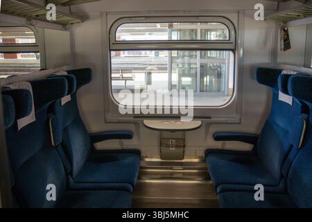 Zugwagen der zweiten Klasse in Polen, die erschwingliche und komfortable Reisen bieten. Einfacher und sauberer Innenraum mit Sitzplätzen für Passagiere, die den erkunden Stockfoto
