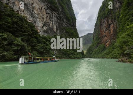 Ausflugsboote nehmen Touristen mit auf eine Reise in den tiefen Canyon des Ma Pi Leng Pass in der Provinz Ha Giang im Norden Vietnams Stockfoto