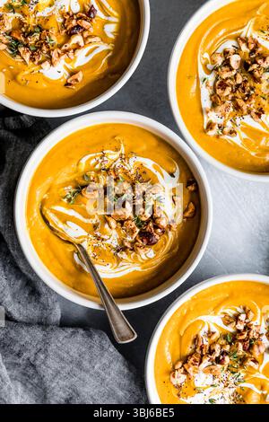 Schüsseln mit cremiger Kürbissuppe garniert mit Nüssen und Kräutern. Stockfoto